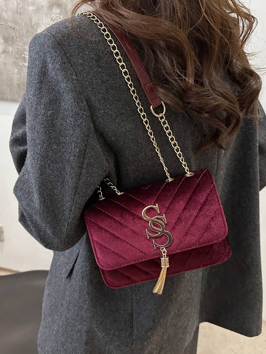 Refined Embossed Letter Shoulder Bag – New Year Collection in burgundy displayed on a woman's shoulder.