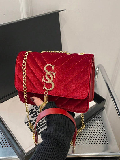 Refined Embossed Letter Shoulder Bag – New Year Collection in red held in a hand with a gold chain strap.
