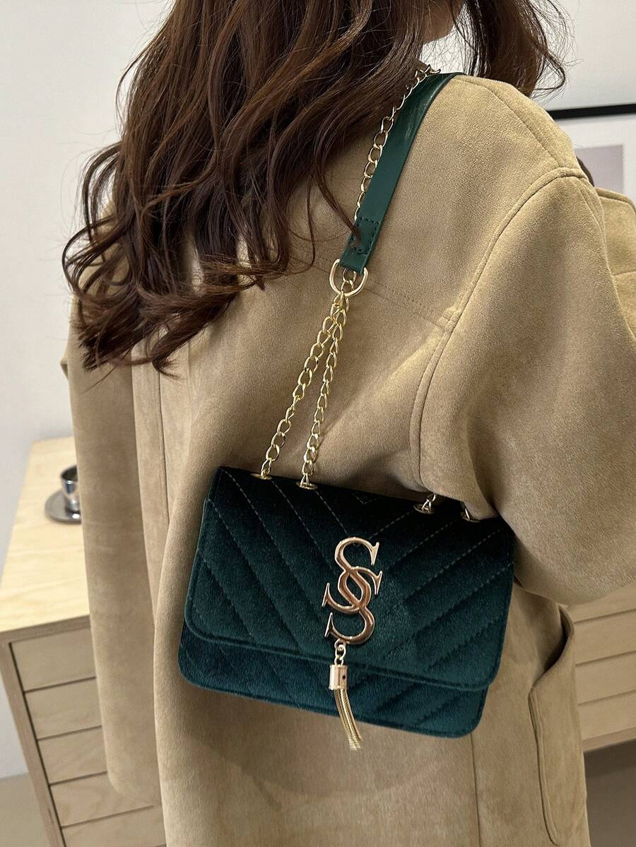 Refined Embossed Letter Shoulder Bag – New Year Collection worn on shoulder by woman in stylish coat.