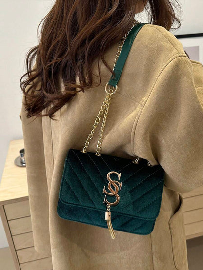 Refined Embossed Letter Shoulder Bag – New Year Collection worn on shoulder by woman in stylish coat.