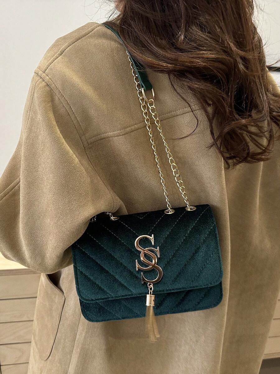 Refined Embossed Letter Shoulder Bag – New Year Collection displayed on a woman in a stylish brown coat.