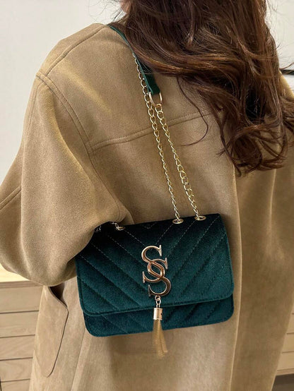 Refined Embossed Letter Shoulder Bag – New Year Collection displayed on a woman in a stylish brown coat.