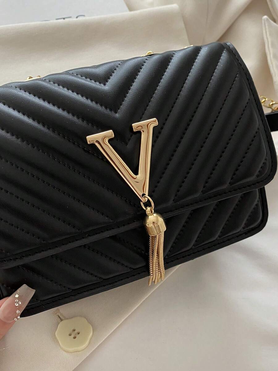 Refined Embossed Letter Shoulder Bag – New Year Collection in black with gold detailing and tassel