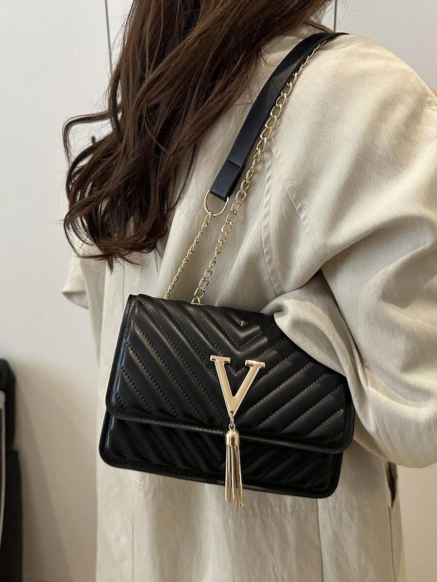 Refined Embossed Letter Shoulder Bag – New Year Collection worn by a woman in stylish outfit.