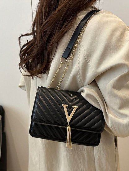 Refined Embossed Letter Shoulder Bag – New Year Collection worn by a woman in stylish outfit.