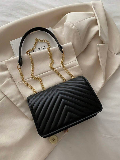 Refined Embossed Letter Shoulder Bag – New Year Collection styled with a chic outfit and gold chain detailing.
