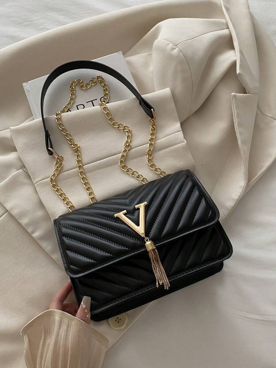 Refined Embossed Letter Shoulder Bag – New Year Collection on a soft background with gold chain detail.