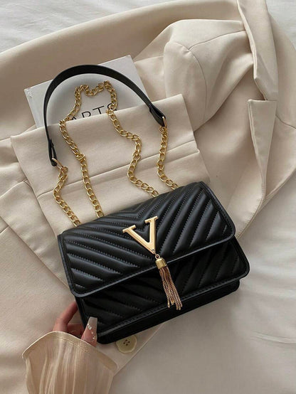 Refined Embossed Letter Shoulder Bag – New Year Collection on a soft background with gold chain detail.