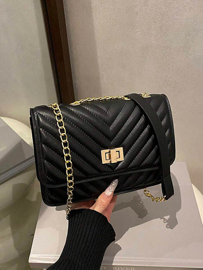 Refined Embossed Letter Shoulder Bag – New Year Collection in black, featuring a chevron design and chain strap.
