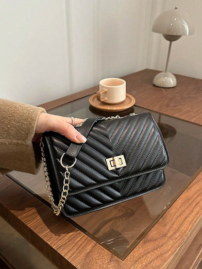 Refined Embossed Letter Shoulder Bag – New Year Collection displayed on a table, featuring elegant quilted design and chain strap.