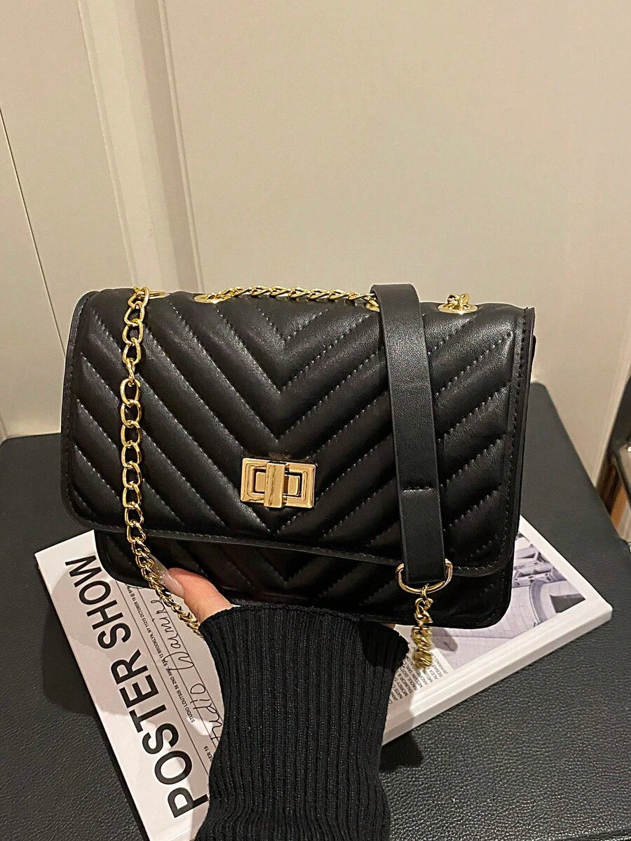 Refined Embossed Letter Shoulder Bag – New Year Collection displayed stylishly with chain strap on a magazine.