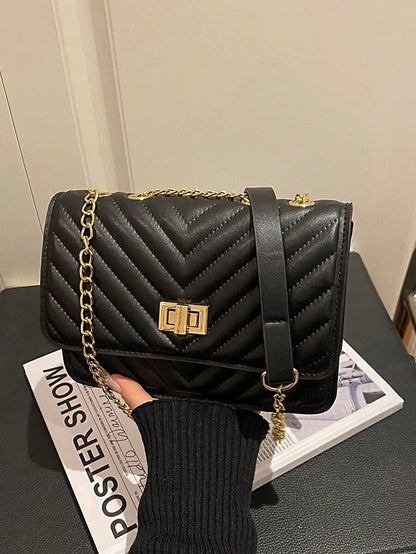 Refined Embossed Letter Shoulder Bag – New Year Collection displayed stylishly with chain strap on a magazine.