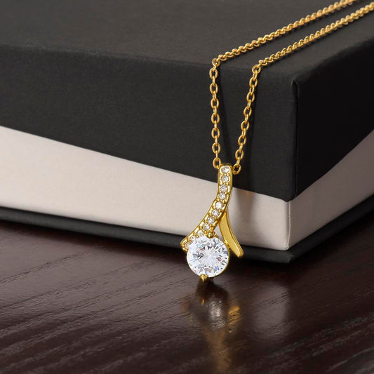 Close-up of Forever Curve Love Necklace, featuring a sparkling cubic zirconia pendant on a gold chain.