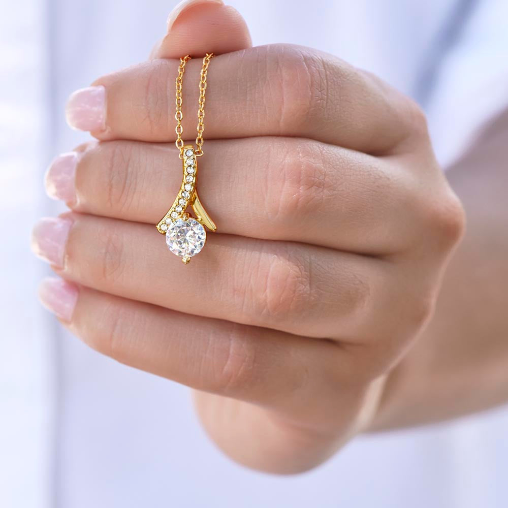 Forever Curve Love Necklace in hand, showcasing gold design with sparkling cubic zirconia stones.