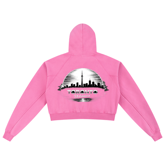 Back view of Urbanova Snow Washed Cropped Hoodie in pink with Toronto skyline graphic.