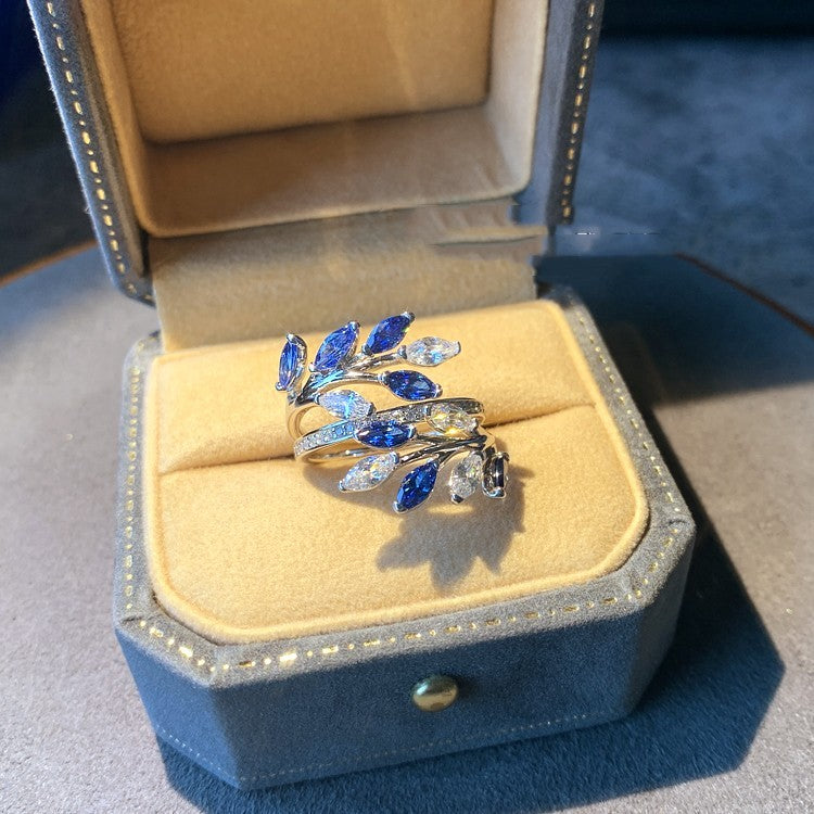 Silver ring with blue and clear gemstones in a jewelry box