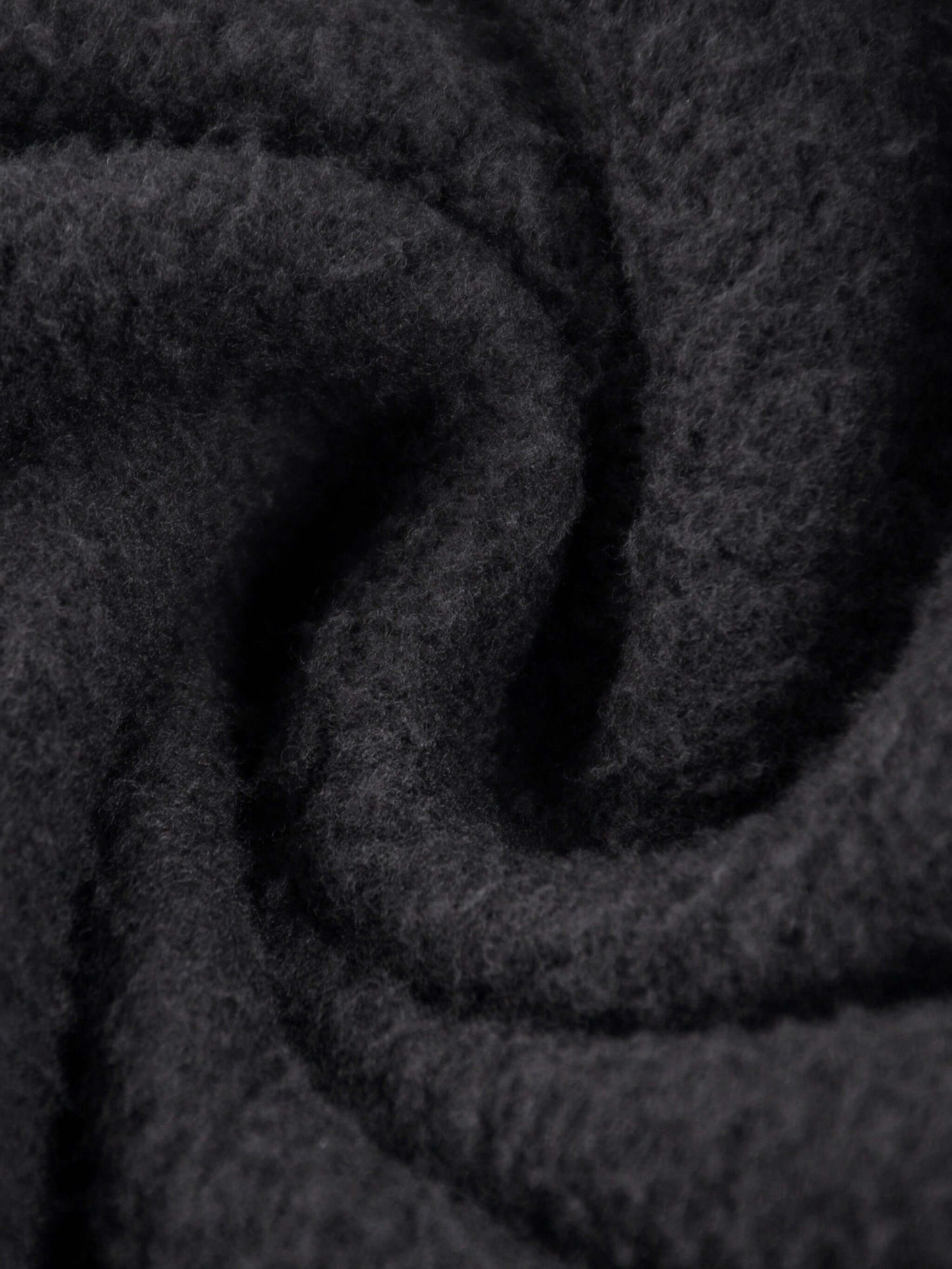 Close-up of soft black fabric showcasing the texture of the URBANOVA-Acid Washed Fleece Hoodie.