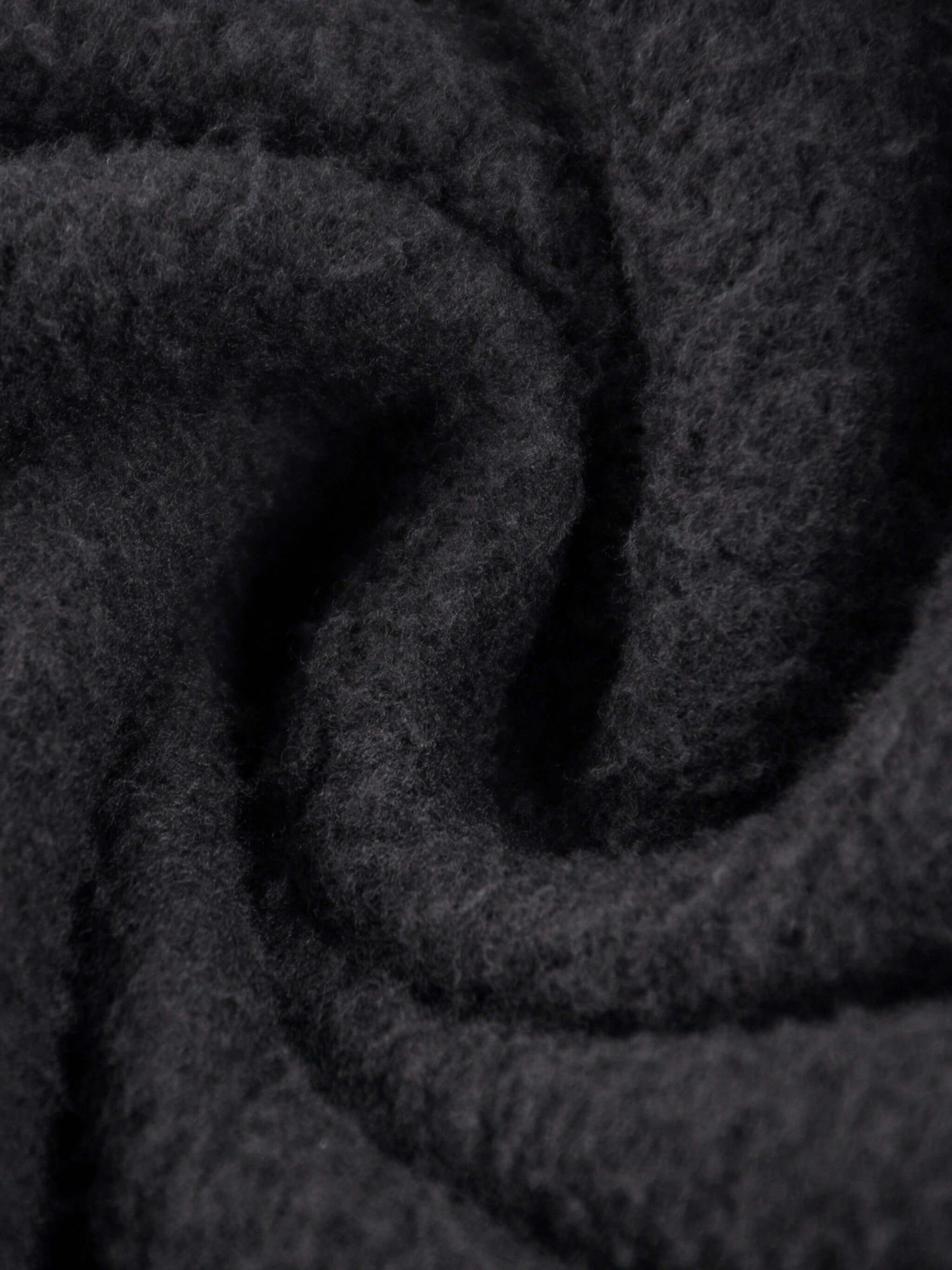 Close-up of soft black fabric showcasing the texture of the URBANOVA-Acid Washed Fleece Hoodie.