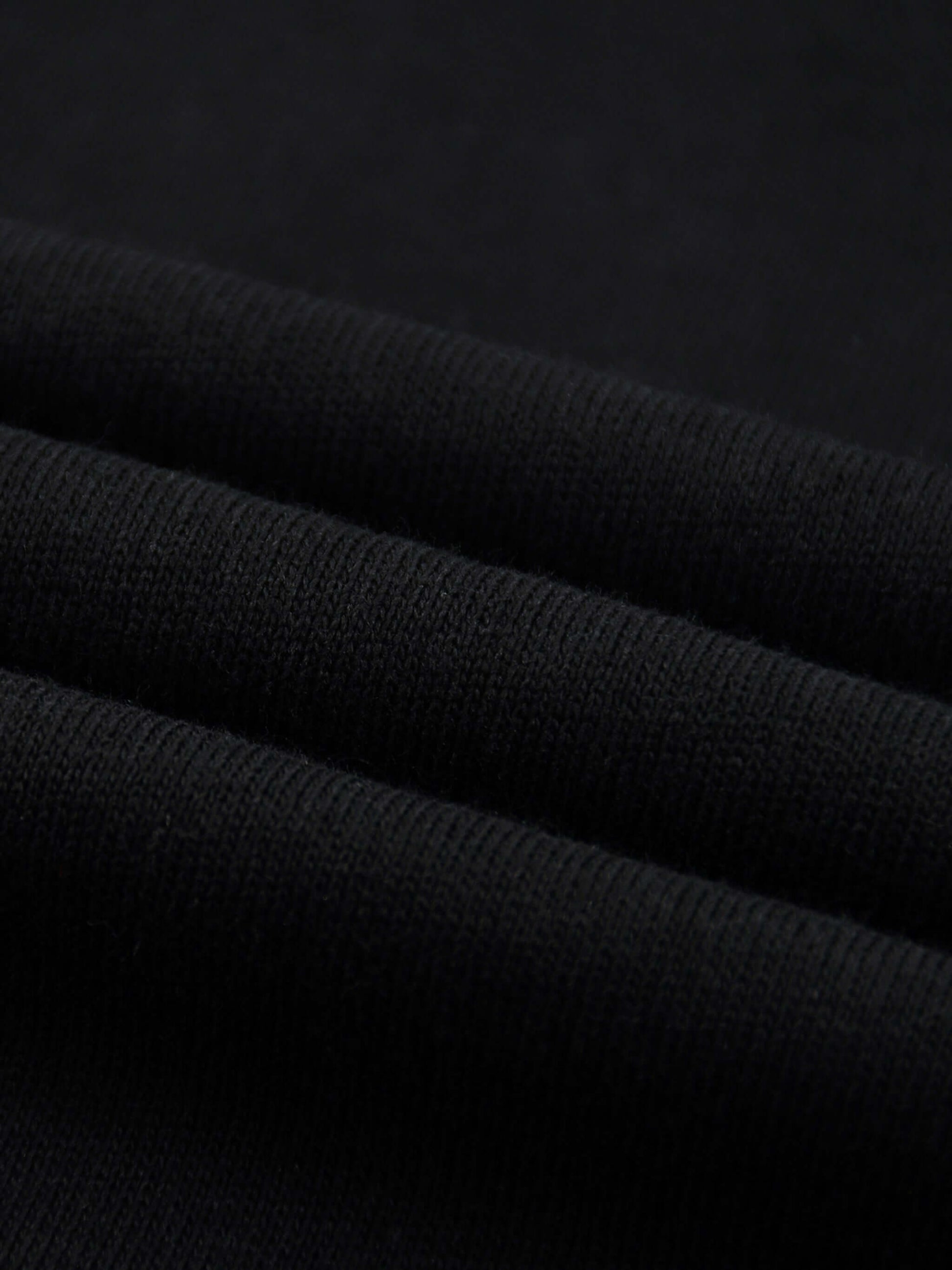 Lightweight Cotton Classic Fit T-Shirt fabric close-up showing soft, thin black cotton texture.
